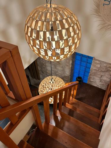 a chandelier hanging over a wooden staircase with a wooden stair case at Villa'S in Zaouiet Bouzarktoune