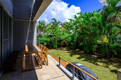 a porch with a table and benches on a house at onna resort nakadomari ビーチまで車で4分 最大8名OK 中庭付き貸切ヴィラでくつろぐ恩納村ステイ in Onna