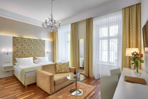 a hotel room with a bed and a couch and a table at Hotel Wandl in Vienna
