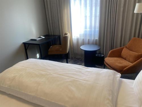 a hotel room with a bed and a desk and a chair at Best Western Plus Kalmarsund Hotell in Kalmar