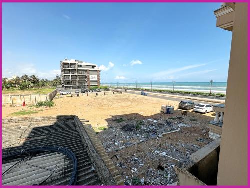 a view of a beach with a building and the ocean at Hotel Dreamland - Fully Air Conditioning Luxuary Rooms - Lift - Restaurant & Parking Facilitie-A Top Rated Four Star Hotel in Bodh Gaya
