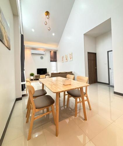 a dining room and living room with a wooden table and chairs at D sleep Villa Chiangmai in Chiang Mai