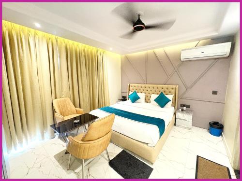 a bedroom with a bed and a desk and chairs at Hotel Dreamland - Fully Air Conditioning Luxuary Rooms - Lift - Restaurant & Parking Facilitie-A Top Rated Four Star Hotel in Bodh Gaya