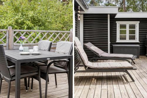 a patio with a table and chairs on a deck at 2730-Nexo-Ostre-Strandvej-22 in Dueodde