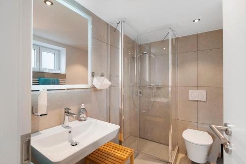 a bathroom with a shower and a sink and a toilet at Fewo Weitblick - Haus Sommerberg in Baiersbronn