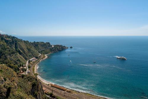 a view of a beach with boats in the water at Excelsior Palace Hotel in Taormina