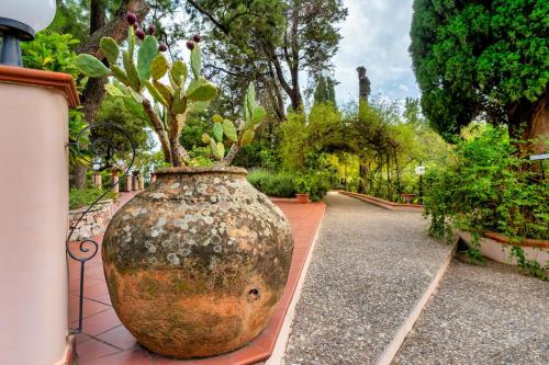 a large vase with a plant in it on a sidewalk at Excelsior Palace Hotel in Taormina