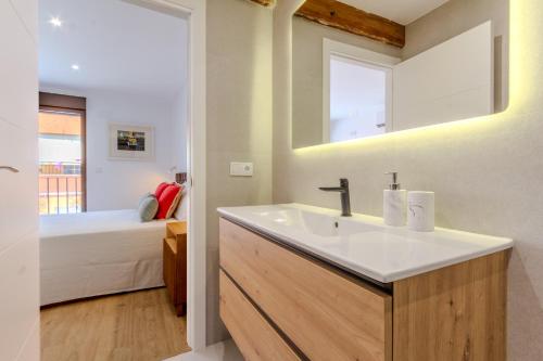 a bathroom with a sink and a bedroom with a bed at La Casa de la tía Libre - Entorno rural y descanso in Tibi