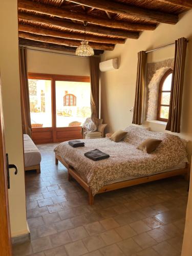 a bedroom with a large bed and a large window at Villa'S in Zaouiet Bouzarktoune