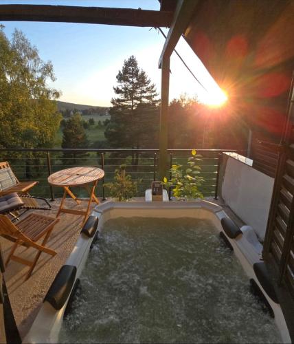 a hot tub on a patio with a table and the sun at Sveti Pantelejmon Divčibare in Divčibare