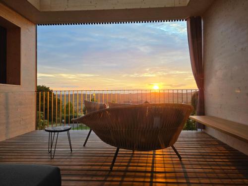 a balcony with a table and a chair on a deck at Stock & Stein Lodges in Bad Gleichenberg