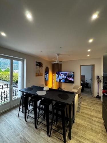 a living room with a black table and a couch at Appartement cosy face au château de Lourdes in Lourdes