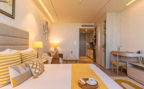 a living room with a couch and a kitchen at Golden Hour Studio Life in aipl joystreet in Gurgaon