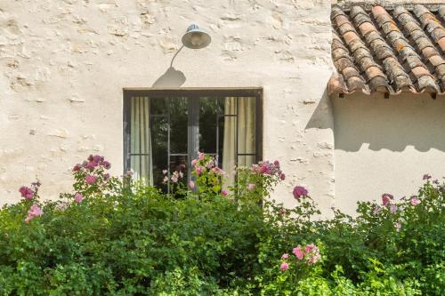 a window of a building with flowers in front of it at Proche l'Isle/Sorgue, loft avec SPA et Piscine in Le Thor