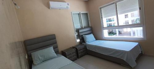 a bedroom with two beds and a window at Prestigia luxury appartement in Fès