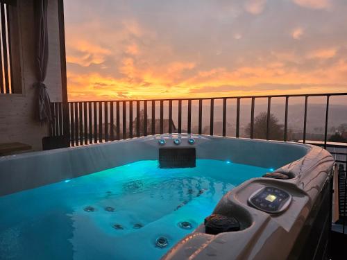 a jacuzzi tub on a balcony with a sunset at Stock & Stein Lodges in Bad Gleichenberg