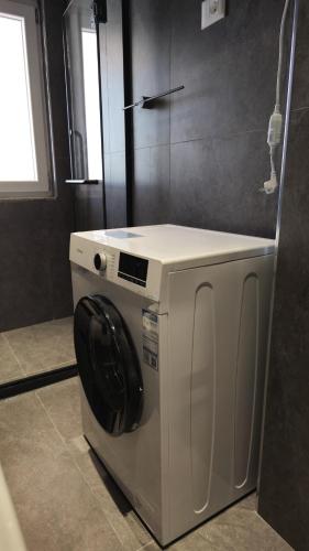 a white washing machine in a bathroom with a window at Hermanos Apartments 702 in Shëngjin