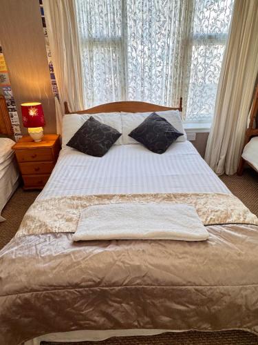 a bedroom with a bed with white sheets and a window at Kendal Hotel in Blackpool