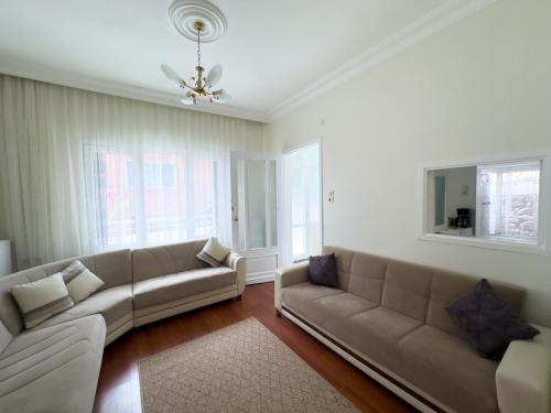 a living room with a couch and two windows at Garden House Heybeliada in Adalar