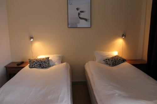 two beds in a room with lights on the wall at Stationshusets Hotell och Café in Köping
