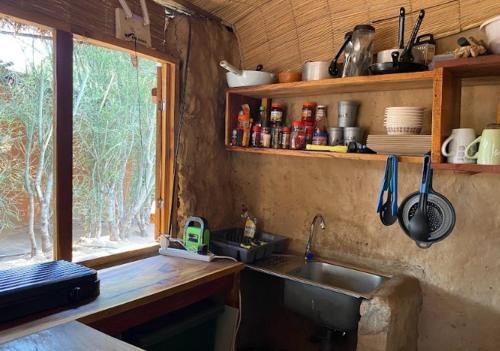 a kitchen with a sink and a window at Muke Village Guest House in Livingstone
