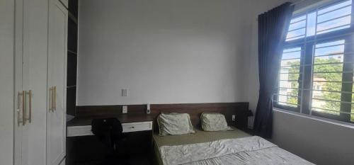 a bedroom with a bed and a window at COMIC Homestay in Danang