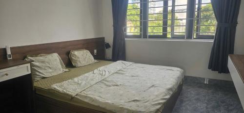 a bedroom with a bed and a window at COMIC Homestay in Danang