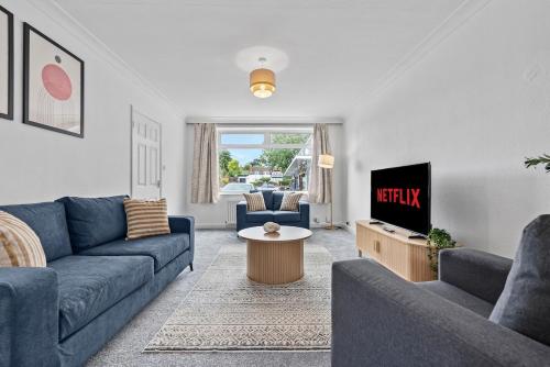 a living room with a blue couch and a tv at NEW! Spacious 4 bedroom 4BR with Private Parking near city Centre in Leamington Spa