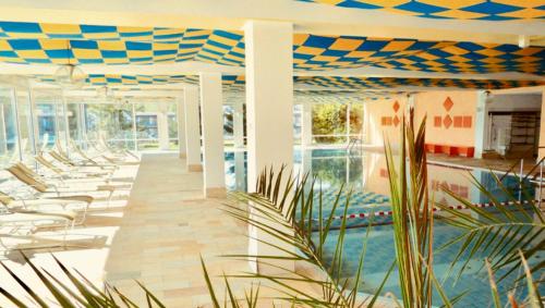 a resort with a pool and lounge chairs at Ferienwohnung Allgäu-Harmonie - Pool, Sauna, Bergblick, 2 Zimmer in Scheidegg