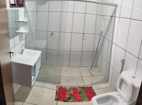 une salle de bain avec douche, lavabo et toilettes dans l'établissement Casa temporada Vovó Ilda, à Olímpia