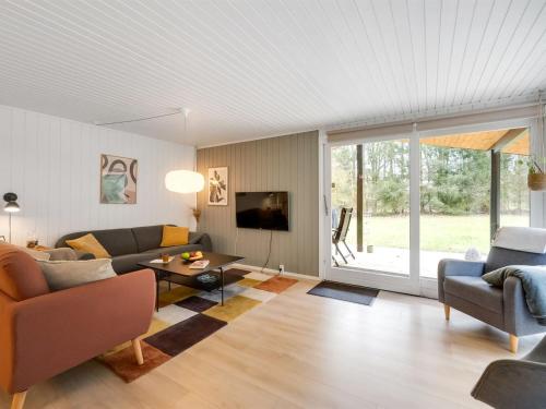 a living room with a couch and a table at Holiday Home Gudrid - 250m to the fjord by Interhome in Højslev