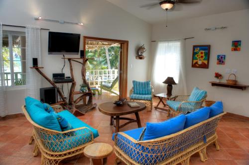 a living room with blue furniture and a tv at Caye Casa in San Pedro