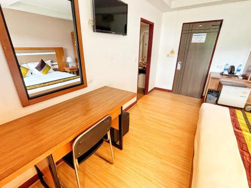 a room with a mirror and a bed and a desk at patong v hotel in Patong Beach