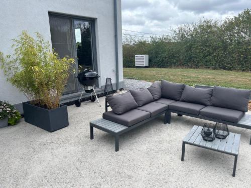 a couch and a coffee table in front of a house at La maison du Gouty in Froid-Chapelle