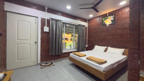 a bedroom with a bed and a window and a door at Magnolia Fields in Neral