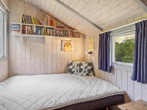 a small bedroom with a bed in a tiny house at Holiday Home Dorti - 725m from the sea by Interhome in Nyrup