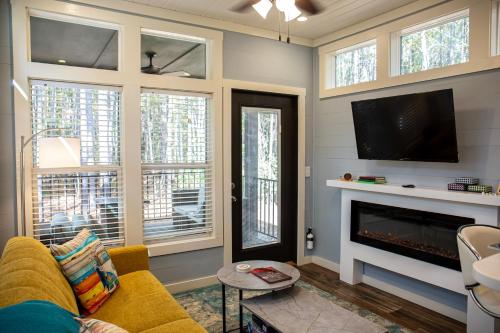 - un salon avec un canapé jaune et une cheminée dans l'établissement Tiny Home Lookout Mountain - Near Downtown & Falls, à Mentone