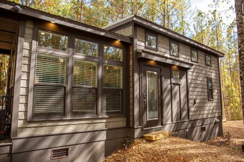 une petite maison avec des fenêtres dans les bois dans l'établissement Tiny Home Lookout Mountain - Near Downtown & Falls, à Mentone