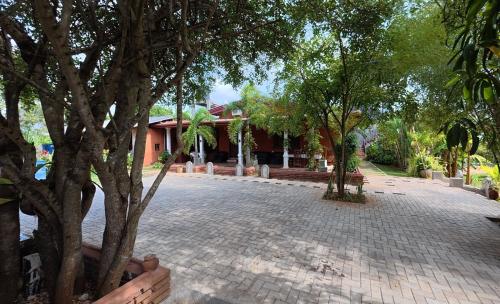 a brick courtyard with trees in front of a building at Meegahapokuna Resort in Anuradhapura