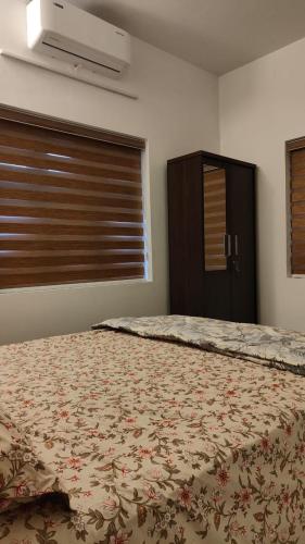 a bedroom with a bed and a window with a bedspread at Beach Stay in Kozhikode