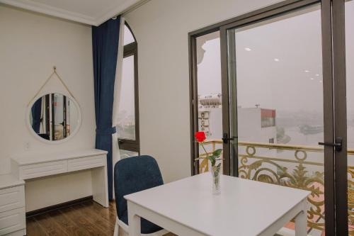 a room with a table and a mirror and a window at Khách sạn QUEENIE in Hai Phong