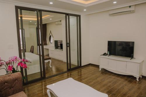 a living room with a television and a couch at Khách sạn QUEENIE in Hai Phong