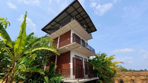 a house in the middle of a field at Meegahapokuna Resort in Anuradhapura