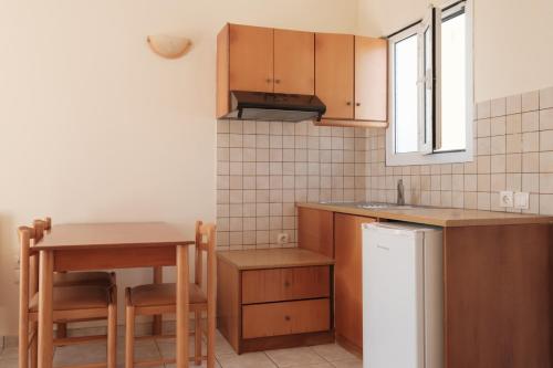 a kitchen with a table and a small table and a table and a tablektop at Paradise Hotel Apartments Sidari in Sidari