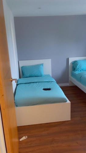 a bedroom with a bed with blue pillows at Modern City Flat, Walk to Hatfield House, Trains and University in Hatfield
