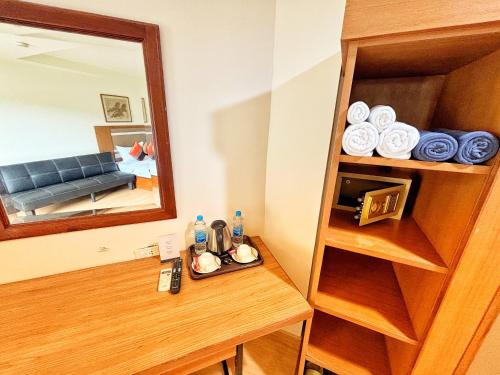 a bathroom with a mirror and a wooden table at patong v hotel in Patong Beach