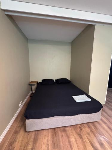 a bedroom with a bed in a room with wooden floors at Loft apartment in Kouvola