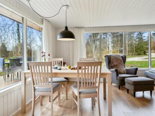 a dining room with a table and chairs and windows at Holiday Home Dome - 12km from the sea by Interhome in Rønde