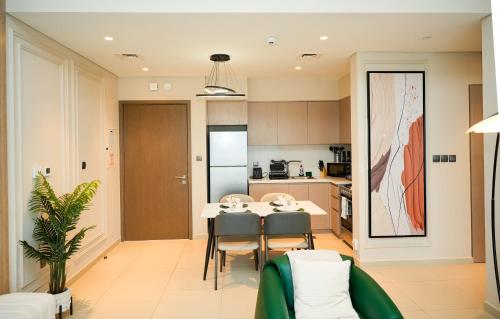 a kitchen and dining room with a table and chairs at Chic 1BR Retreat , Blvd Views, Walk to Dubai Mall in Dubai