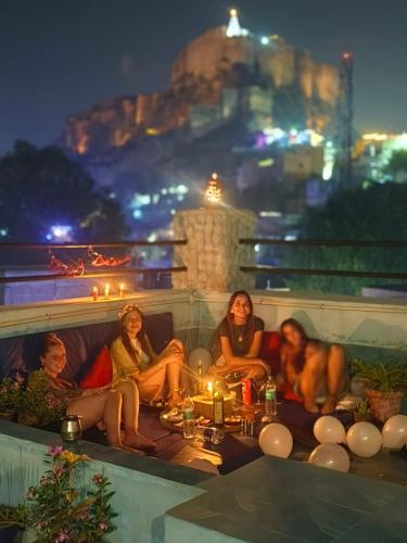 a group of women sitting on a couch with a dog at Shikhar Niwas in Jodhpur